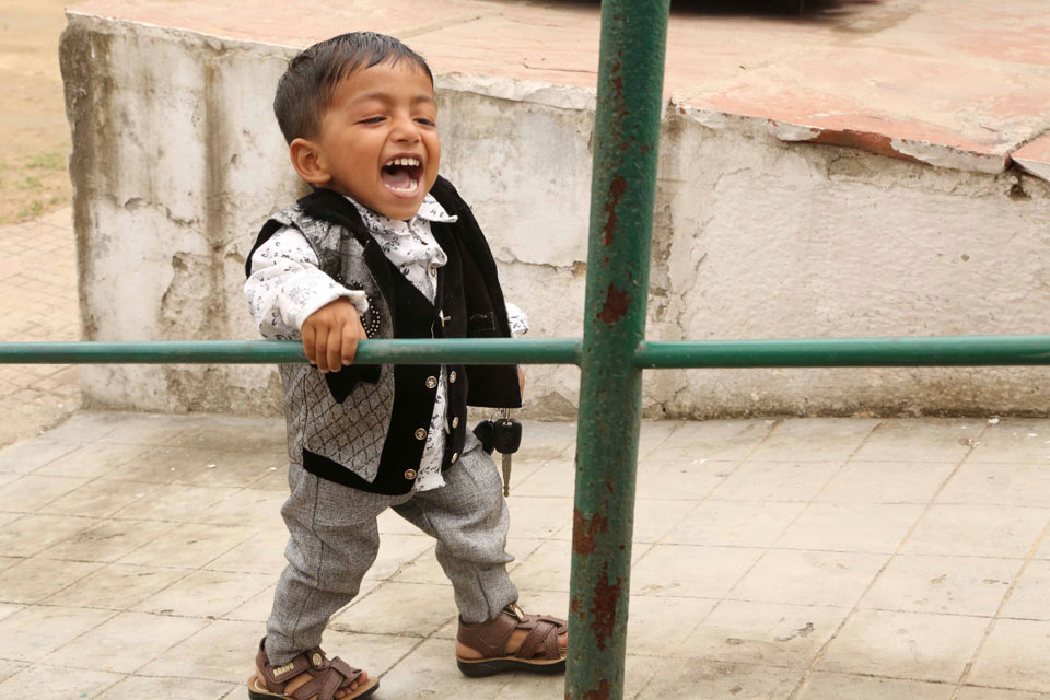 En väldigt glad liten pojke går upp för en ramp.